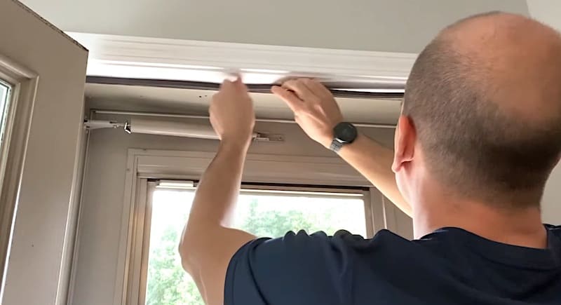 Pressing the new piece of weatherstripping into place