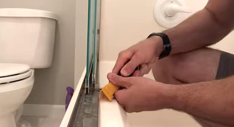 Dislodging the sealant with a caulk removal tool