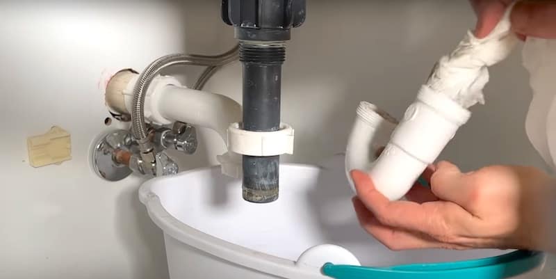 How to Unclog a Bathroom Sink Drain: cleaning the P-trap with rolled-up paper towels