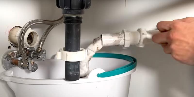 Cleaning the gooseneck by pushing rolled-up paper towels through the pipe