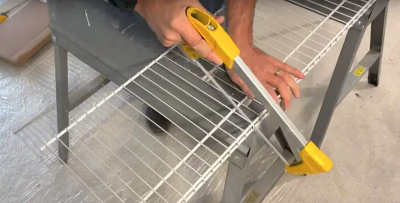 Cutting the wire shelf with a hacksaw