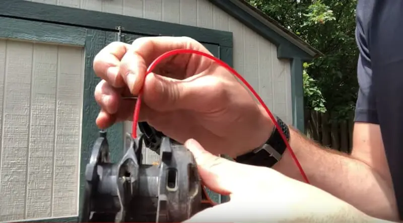 Feeding the line into one of the holes on the spool