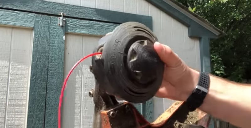 Inserting line into exterior hole of the trimmer head