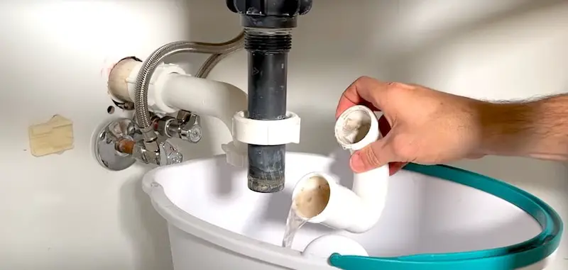 How to Unclog a Bathroom Sink Drain: Dumping the water out after removing the P-trap
