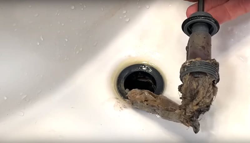 How To Unclog A Bathroom Sink Drain: Tail of gunk and hair stuck to the drain stopper