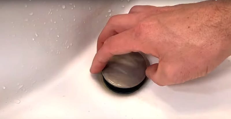 How To Unclog A Bathroom Sink Drain: Rotating the top of the "push" drain stopper counter-clockwise to remove it