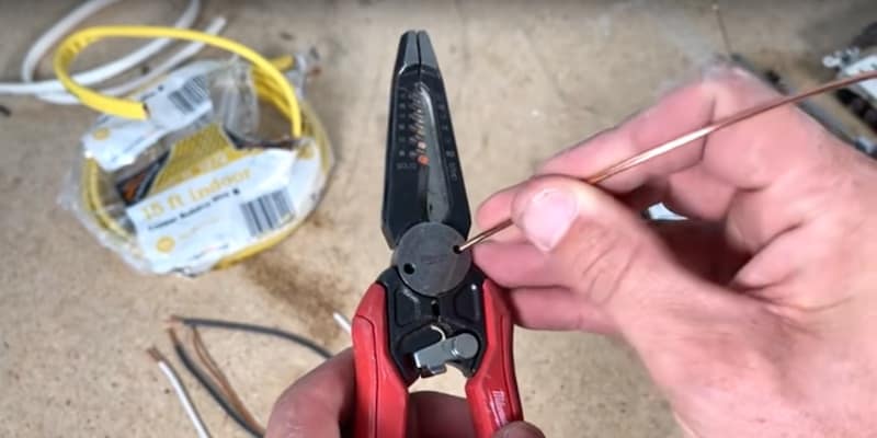 Creating a J-hook using wire strippers  (insert the wire into the hole)