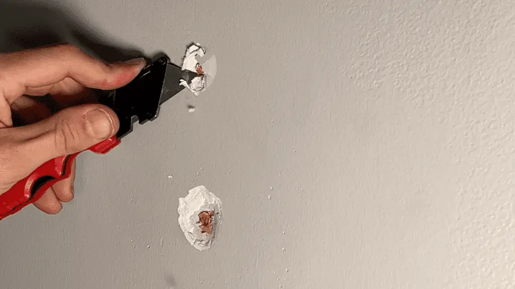 Cutting away loose drywall material from a nail pop