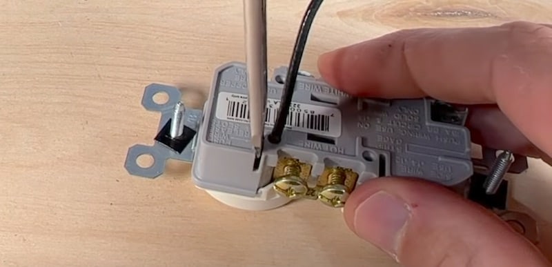 Inserting a flathead screwdriver to release the speed wire