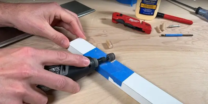 Fix Damaged Ikea Furniture: Sanding down the cut down with a Dremel tool