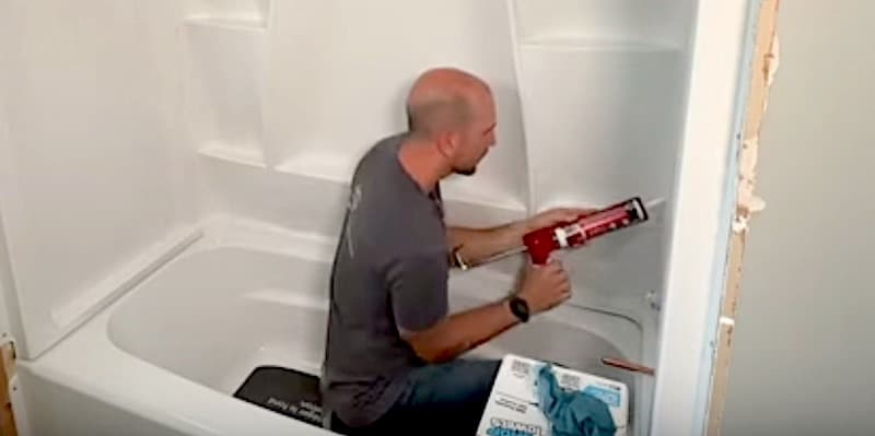 How to Install a Bathtub & Shower Surround Final step: applying sealant along the seams