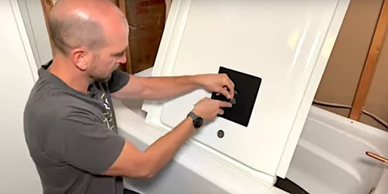 Applying a heat-resistant patch to the back of the end panel of the tub surround
