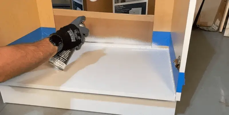 How to Waterproof a Cabinet Base with Flex Seal: Using a piece of cardboard to catch overspray