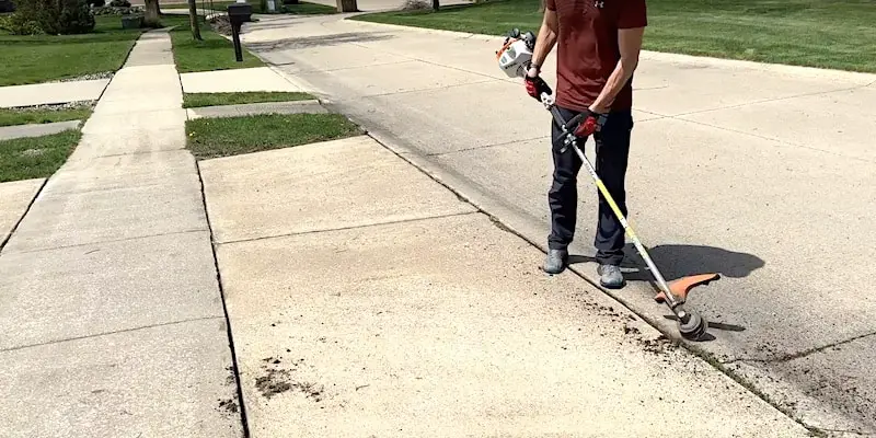 A string trimmer is handy for removing vegetation in expansion joints and cracks