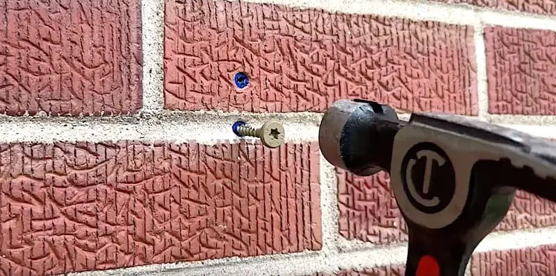 Drilling into Brick and Mortar: Tapping in the wall plug until it sinks just past the surface